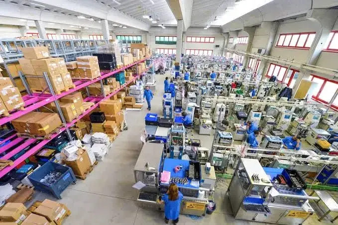 Manufacturing warehouse with workers handling production, inventory, and order fulfillment operations